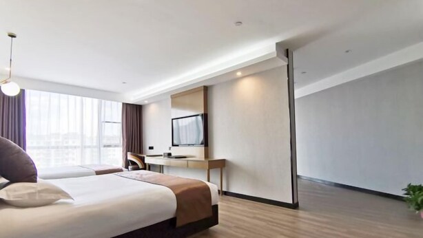 A modern hotel room with a large bed, a desk, a TV, and a large window. - GYA Hotell(Jingjiang gongsuoqiao store&Jiangyin Industrial Park ) (Jingjiang)
