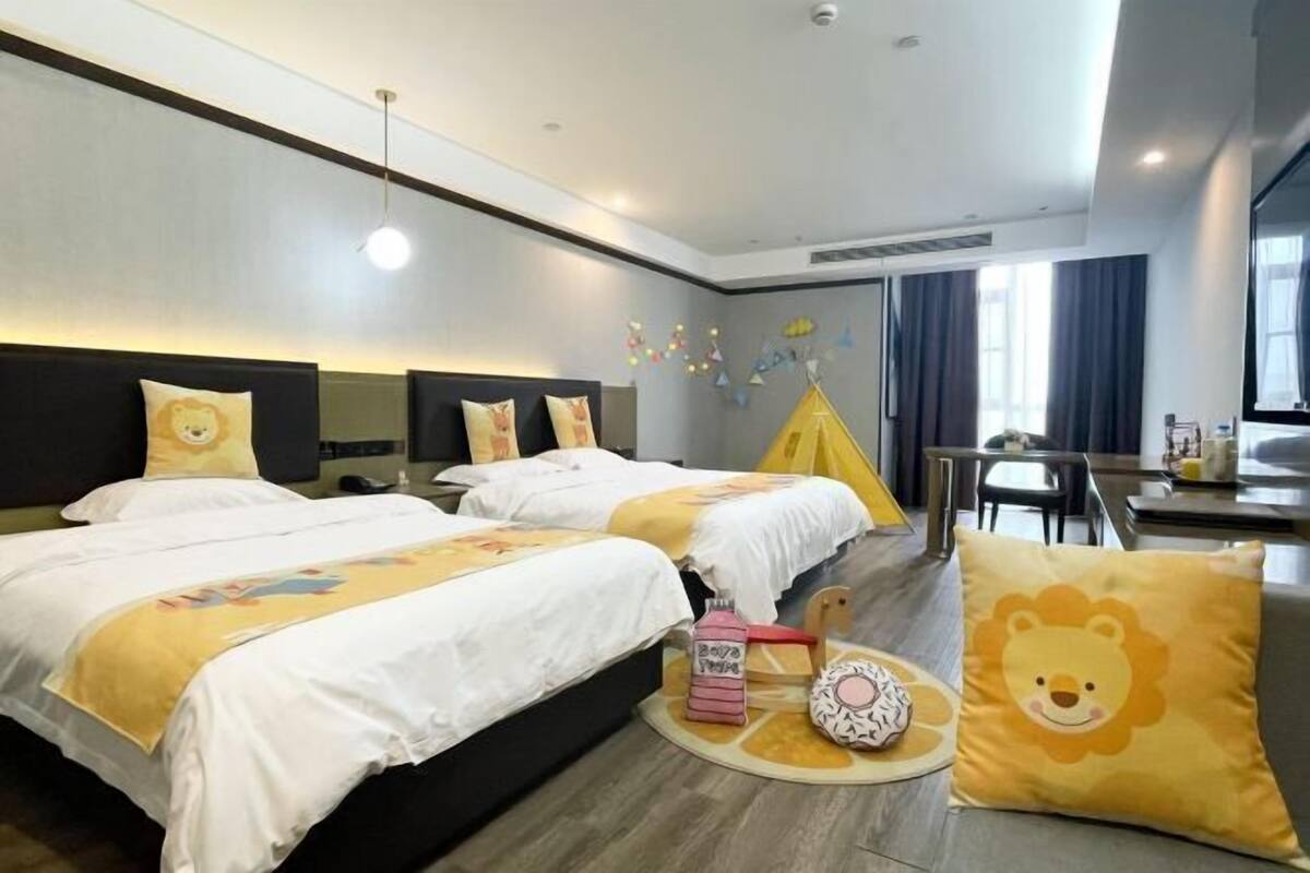 A hotel room with two beds, a dining area, and a window with curtains.