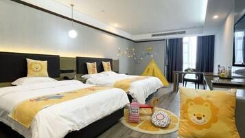 Een hotelkamer met twee bedden, een zithoek en een raam met gordijnen.