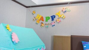 A child's room with a 'HAPPY' banner, a bed with a blue canopy, and a pillow with 'Peppa Pig' branding. - GYA Hotell(Jingjiang gongsuoqiao store&Jiangyin Industrial Park ) (Jingjiang)