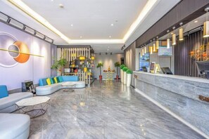 A modern hotel lobby with a curved seating area, a reception desk, and a decorative wall. - GYA Hotell(Jingjiang gongsuoqiao store&Jiangyin Industrial Park ) (Jingjiang)