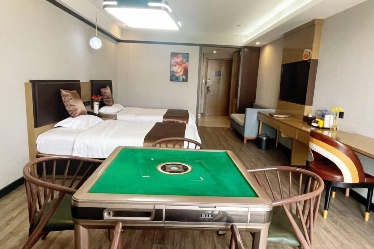 Camera d'albergo con due letti, una scrivania, una sedia e un tavolo da biliardo.