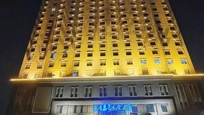 A high-rise hotel with multiple floors, illuminated windows, and a visible restaurant sign at the ground level. - JIA HAO HOTEL INTERNATIONAL PLAZA WUHAN (Wuhan)