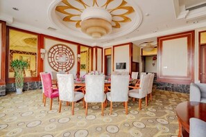 Un espace repas comprenant une table ronde, des chaises et un tapis à motifs.