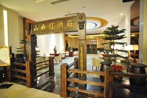 A hotel lobby with a reception desk, a staircase, and a Christmas tree. - JIA HAO HOTEL INTERNATIONAL PLAZA WUHAN (Wuhan)