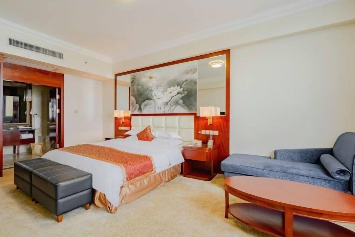 Une chambre d’hôtel comprenant un lit, un bureau, une chaise, un canapé et une petite table.