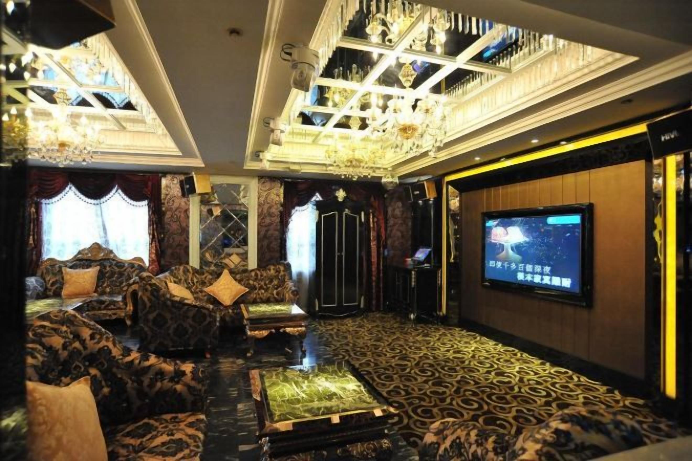 Una habitación lujosa con un amplio espacio de estar, televisor y una alfombra estampada.