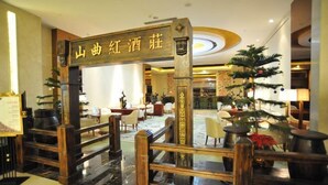A lobby with a traditional Chinese gate, a reception desk, and a seating area with tables and chairs. - JIA HAO HOTEL INTERNATIONAL PLAZA WUHAN (Wuhan)