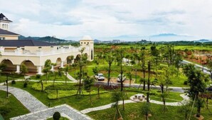 Un hotel con un patio, un edificio grande con arcos y vistas del paisaje circundante.