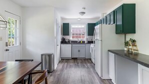 Een moderne keuken met witte kastjes, een zwart aanrecht en een raam met uitzicht.