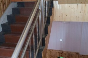 A staircase with a metal railing and a wooden floor. - moranju hotel (Zhangjiajie)