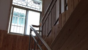 A wooden interior with a metal staircase and a window with a decorative grille. - moranju hotel (Zhangjiajie)