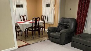 A living room with a dining area, a leather armchair, and a sofa. - Conveniently located 2brm / 1bt Home (Myrtle Grove)