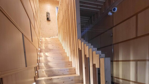 Una scala in legno dal design moderno che conduce a un piano superiore.