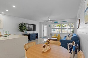 Relax in this stylish living space with a dining table, comfortable sofa, and a potted plant.