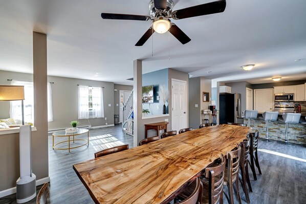 Relax in this open-plan living space with a large dining table and modern kitchen area.