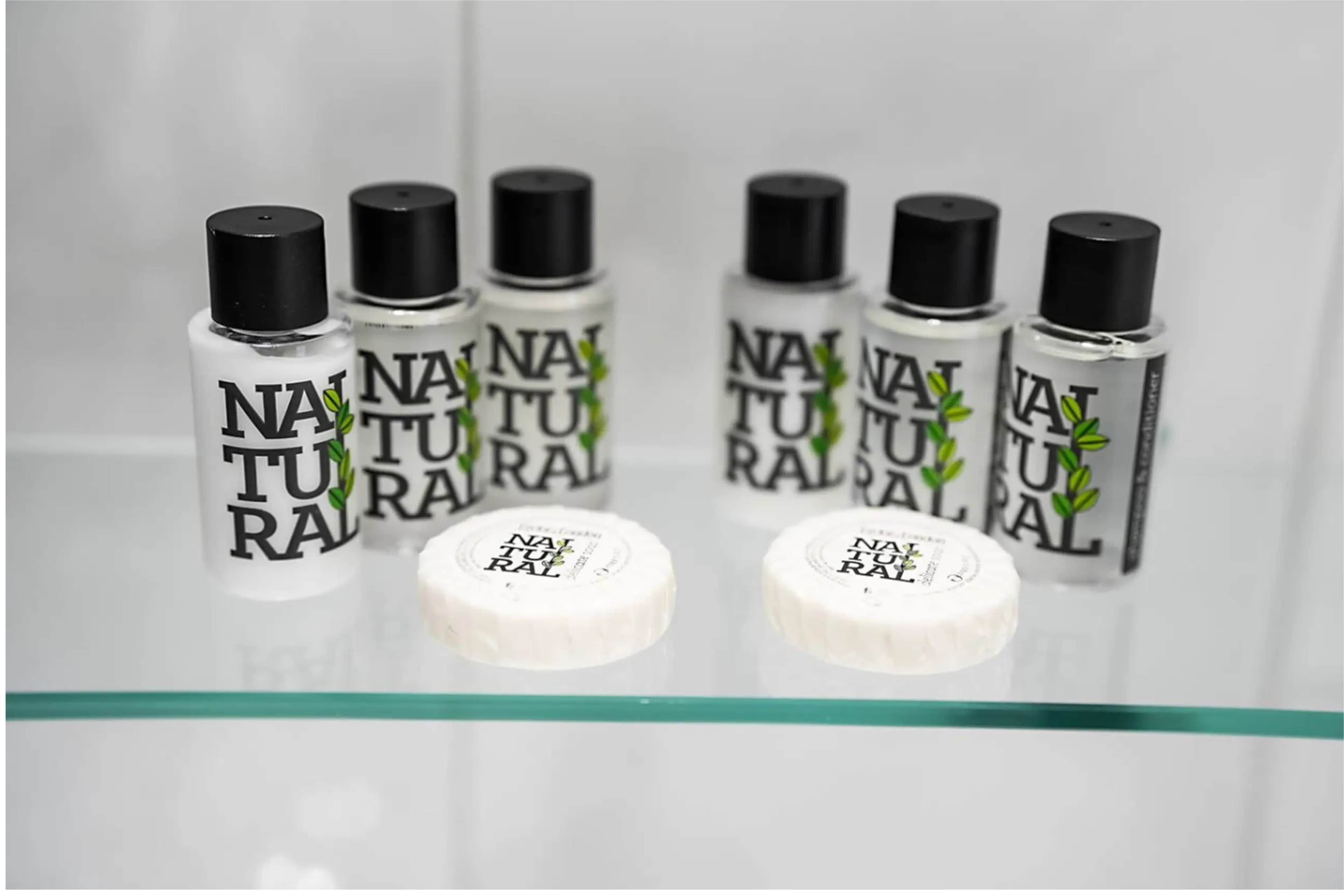 A display of natural toiletry products on a glass shelf.