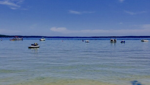 Mar tranquila con barcos y cielo despejado.