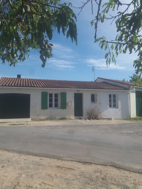 A single-story building with a tiled roof, a garage door, and a small window.