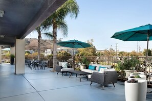 An outdoor patio area with seating, umbrellas, and potted plants. - Affordable Accommodation in Signature Temecula! Onsite Pool, Free Parking (Temecula)