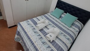 Une chambre à coucher avec un lit, une armoire et un sol carrelé.