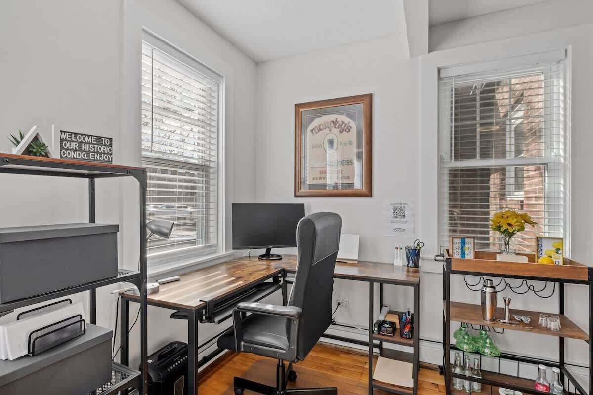 Un espace de bureau moderne comprenant un bureau, une chaise, un ordinateur et des étagères remplies de divers objets.