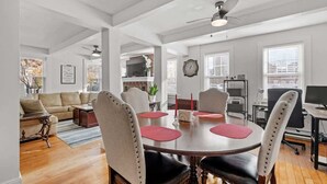 A dining area with a round table, chairs, and a ceiling fan. - Charming & Historic 2BR Oasis in Downtown Luxury (Manchester)