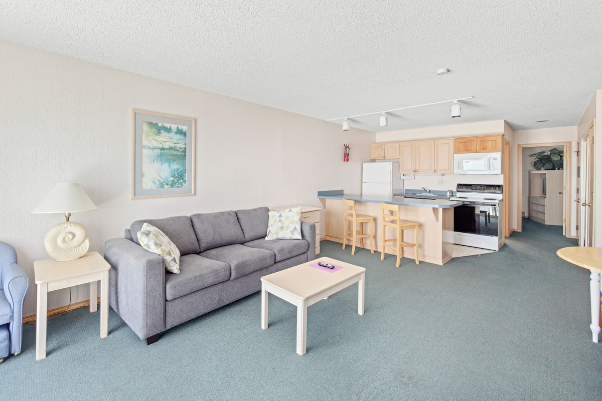 Un appartement moderne comprenant un salon, une cuisine et un coin repas.