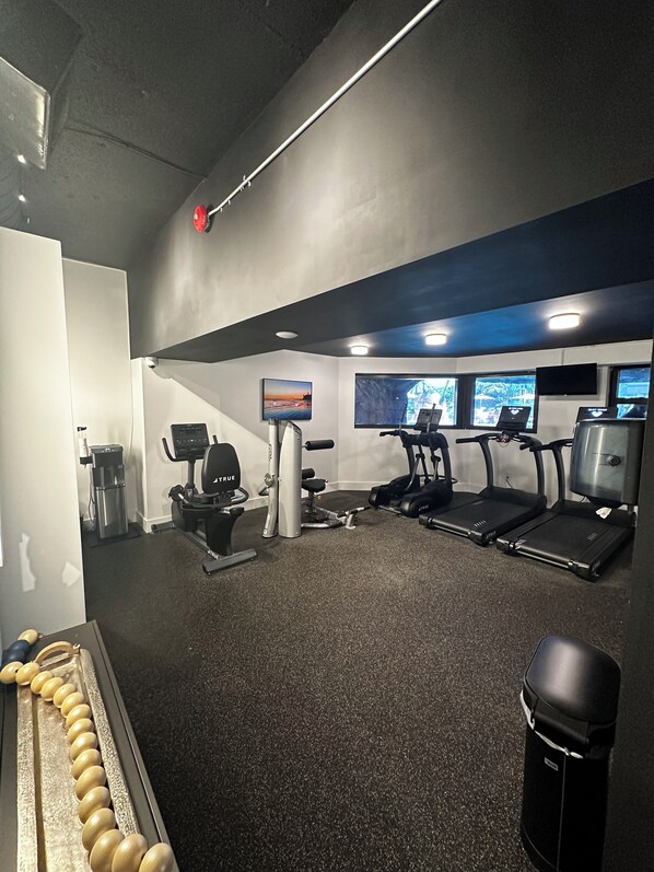 A gym with treadmills, a stationary bike, and a rowing machine.