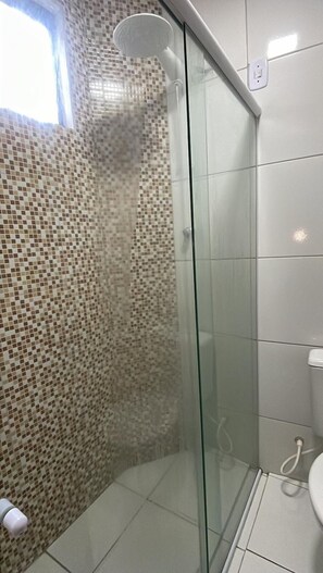 A glass-enclosed shower with mosaic tile walls and a white toilet. - Hotel Pousada Acauã (Campina Grande)