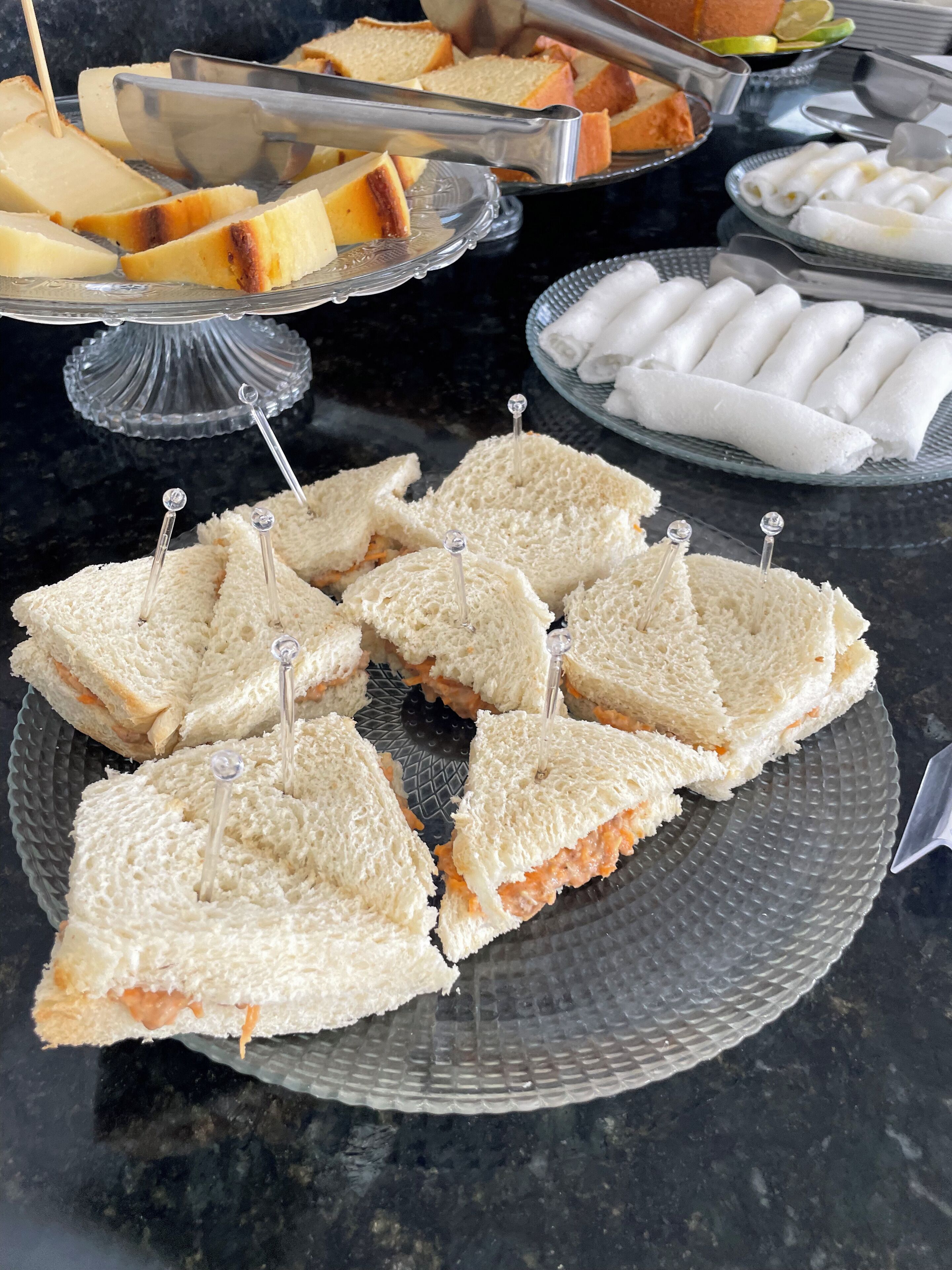 Un bufet amb diferents plats, incloent entrepans, pastissos i altres postres.