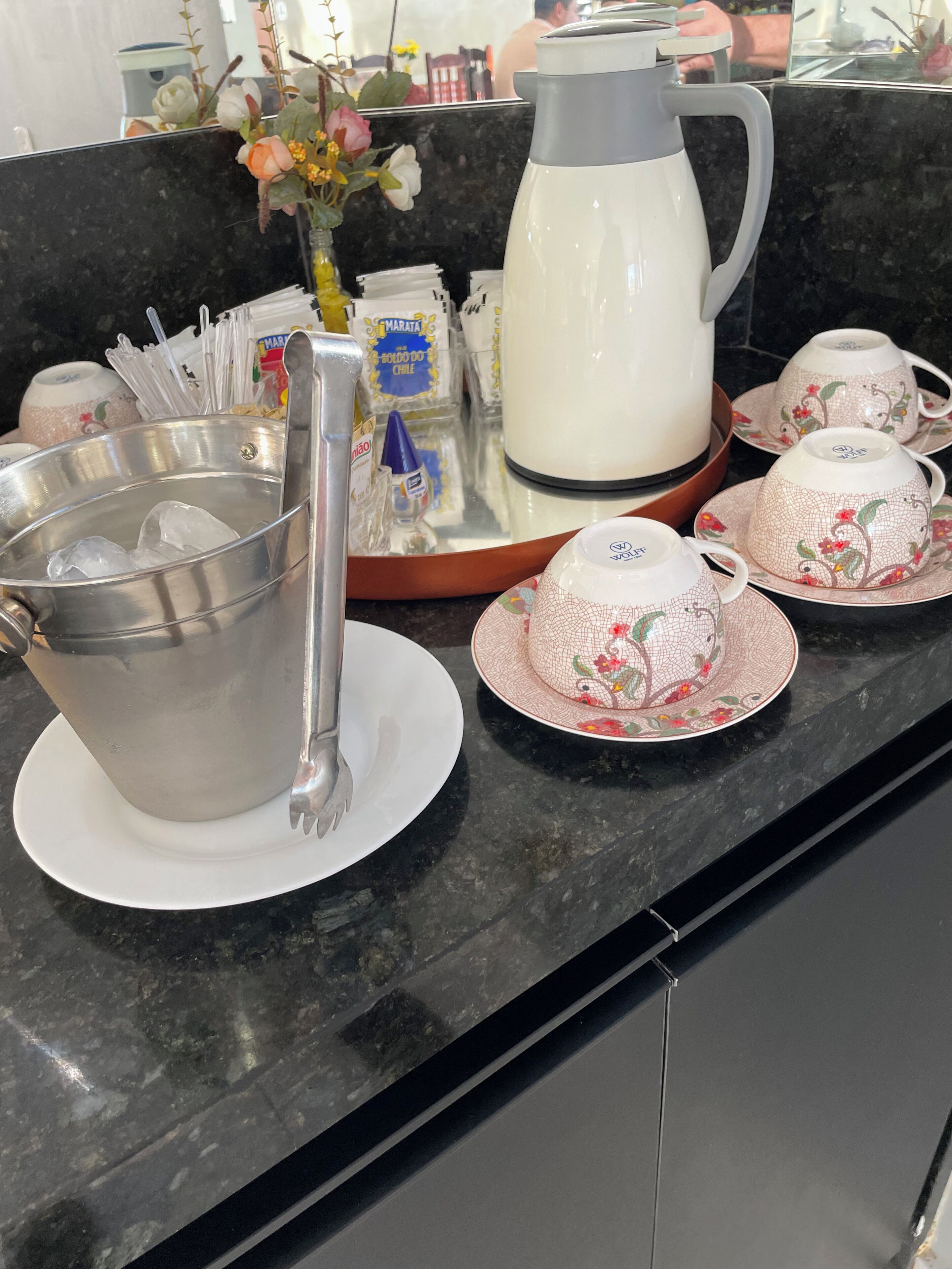 Una encimera de cocina con cafetera, tetera y juego de té.