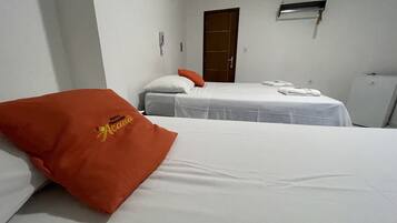 Hotellihuone, jossa on kaksi sänkyä, vaatekaappi ja pieni työpöytä.