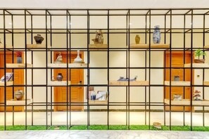 A wall with a grid of shelves displaying various decorative items. - Very Much Pottery Homestay (Fuliang)