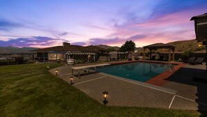 Un área de piscina con una vista despejada del cielo, un quiosco y una zona de estar cubierta.