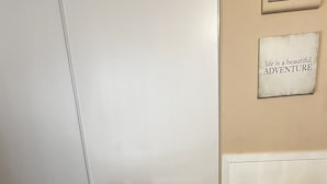 Two upholstered chairs with a small square table between them, a floral-patterned rug, and a wall with a sign that reads 'life is a beautiful ADVENTURE.' - Comfortable, convenient 2BR 2BA apt in Alameda (Alameda)