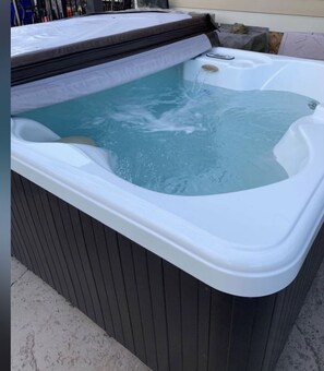 Uma banheira de hidromassagem com exterior de madeira e interior branco.