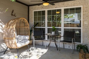 A patio with wicker chairs, a table, and a ceiling fan. - New Home-Hot Tub-GameRoom-Pool table-10min to DFW Airport-12 min from Downtown (Irving)