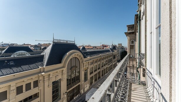 A view of a building with a balcony overlooking a street with other buildings. - GuestReady - Bright Apartment near Bolhão (Porto)