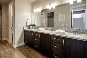 A modern bathroom with a large vanity, dark wood cabinets, a granite countertop, and a large mirror with lights. - Paradise Village 51, Private 20x40 Pool & Sport Court (Santa Clara)