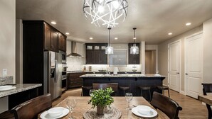 A modern kitchen with dark cabinets, stainless steel appliances, and a central island. - Paradise Village 51, Private 20x40 Pool & Sport Court (Santa Clara)