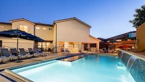 A swimming pool with lounge chairs and umbrellas, surrounded by buildings with a modern design. - Paradise Village 51, Private 20x40 Pool & Sport Court (Santa Clara)