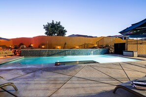 A swimming pool with a stone wall, lounge chairs, and a wooden fence. - Paradise Village 51, Private 20x40 Pool & Sport Court (Santa Clara)