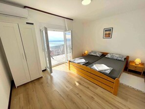 Une chambre à coucher avec un lit en bois, une armoire et un balcon offrant une vue.
