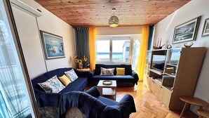 A living room with a sofa, a coffee table, and a TV stand. - Holiday apartment Spacious with terrace and views (Dramalj)