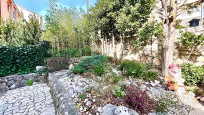 A garden with a stone pathway, various plants, and a statue of a figure. - Holiday apartment Spacious with terrace and views (Dramalj)