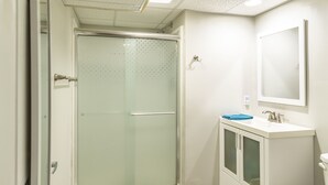 Un baño con ducha, inodoro y lavabo.