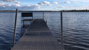 A wooden pier extending into calm water with a bench at the end. - Inviting lake house in the heart of MN lakes country (Dent)