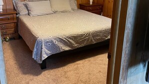 A bedroom with a bed, wooden walls, a ceiling fan, a window with blinds, and a nightstand with a lamp. - Inviting lake house in the heart of MN lakes country (Dent)