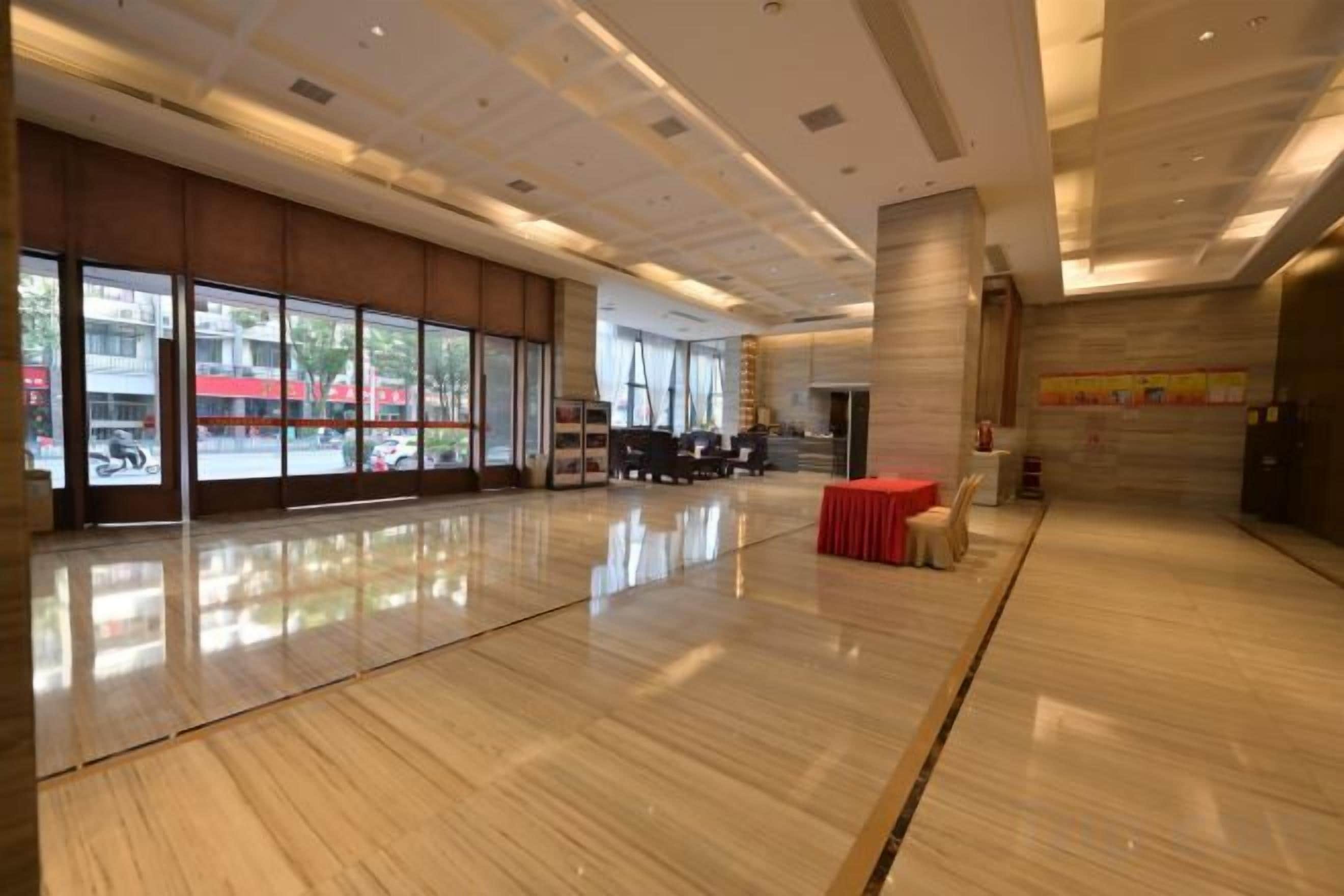 Un hall d’entrée spacieux, doté d’un plancher en bois poli, de grandes fenêtres et d’un comptoir de réception.